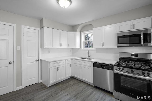 1021 Lakeview Ave, Saint Louis, MO 63138 - kitchen with appliances with stainless steel finishes, a sink, light countertops, white cabinetry, and wood finished floors