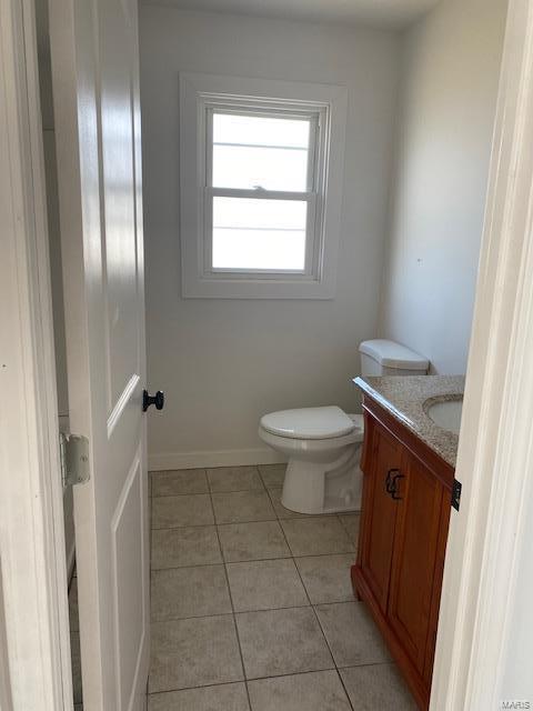 404 Lueking Dr, De Soto, MO 63020 - half bathroom featuring tile patterned flooring, toilet, vanity, and baseboards