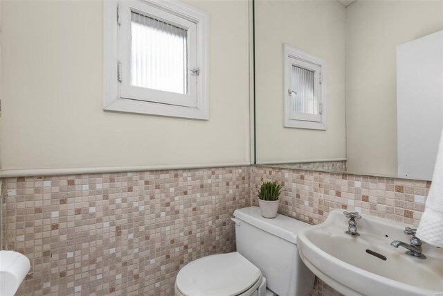 6954 Kingsbury Blvd, University City, MO 63130 - bathroom featuring toilet, a sink, tile walls, and wainscoting