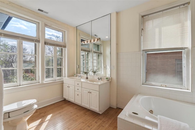 6954 Kingsbury Blvd, University City, MO 63130 - full bathroom with hardwood / wood-style flooring, a tub with jets, double vanity, toilet, and baseboards