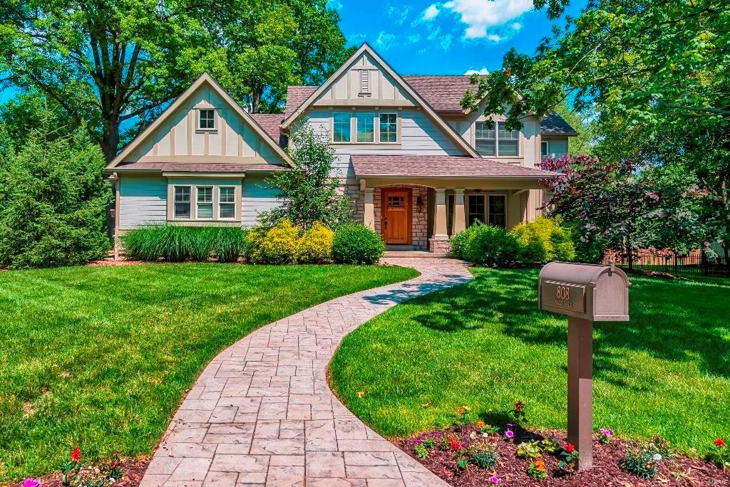 craftsman-style home with a front yard, board and batten siding, and stone siding