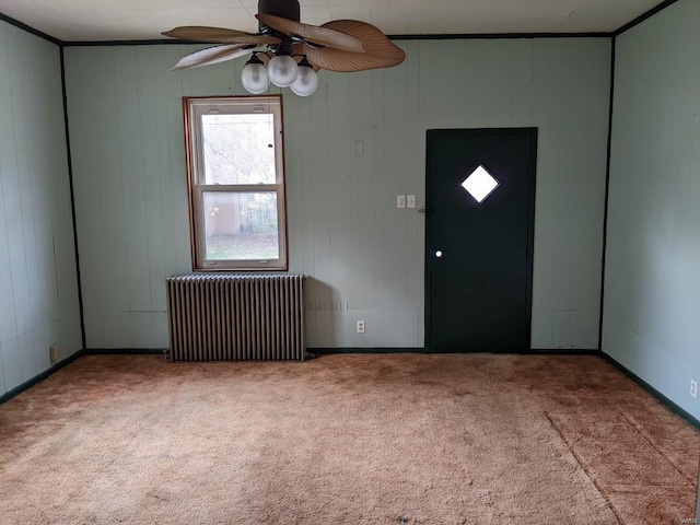 foyer entrance with radiator heating unit, carpet floors, a ceiling fan, and baseboards