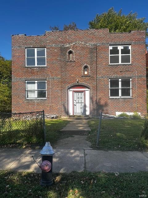 view of front of property featuring brick siding and fence