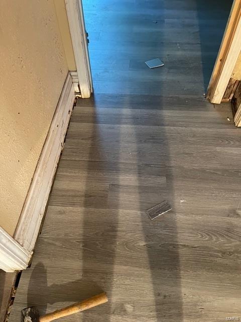 detailed view of wood finished floors and a textured wall