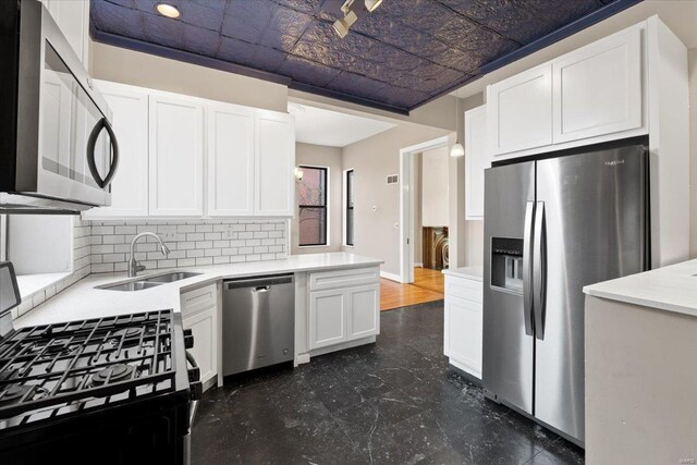 4361 Laclede Ave, Saint Louis, MO 63108 - kitchen featuring stainless steel appliances, a sink, an ornate ceiling, white cabinets, and tasteful backsplash