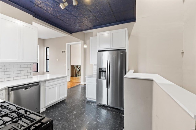 4361 Laclede Ave, Saint Louis, MO 63108 - kitchen with appliances with stainless steel finishes, an ornate ceiling, white cabinetry, light countertops, and tasteful backsplash