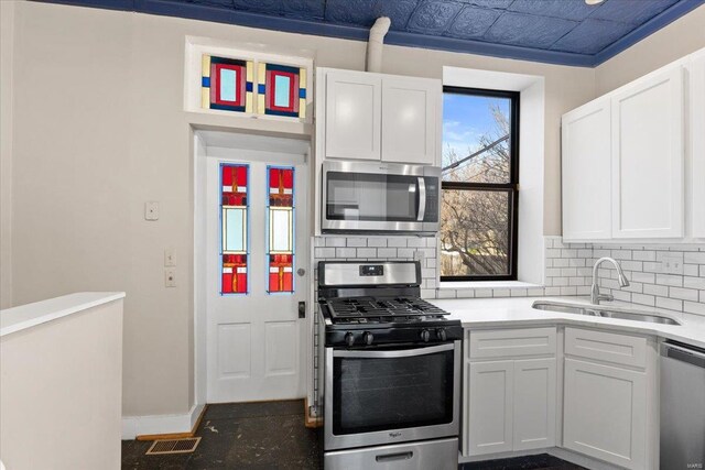 4361 Laclede Ave, Saint Louis, MO 63108 - kitchen featuring stainless steel appliances, a sink, backsplash, and white cabinetry
