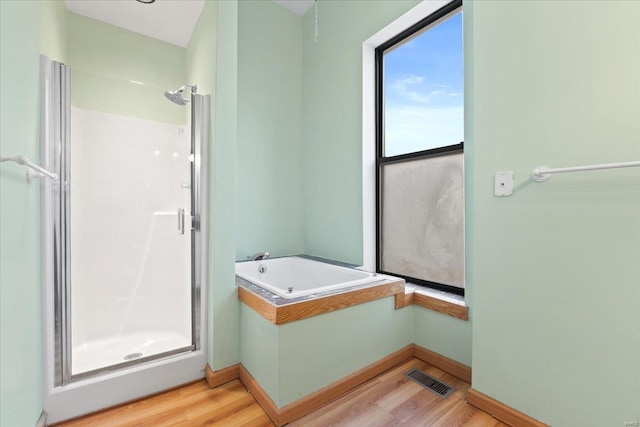 4361 Laclede Ave, Saint Louis, MO 63108 - bathroom featuring a stall shower, wood finished floors, a garden tub, and baseboards
