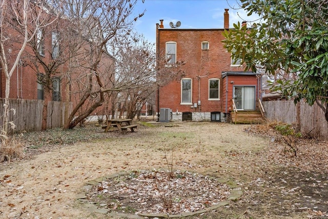 4361 Laclede Ave, Saint Louis, MO 63108 - rear view of house with fence, cooling unit, a chimney, entry steps, and brick siding