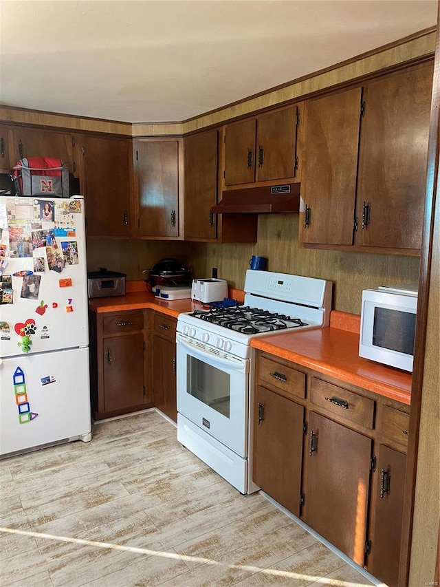 kitchen featuring white appliances, under cabinet range hood, light wood-style flooring, and light countertops