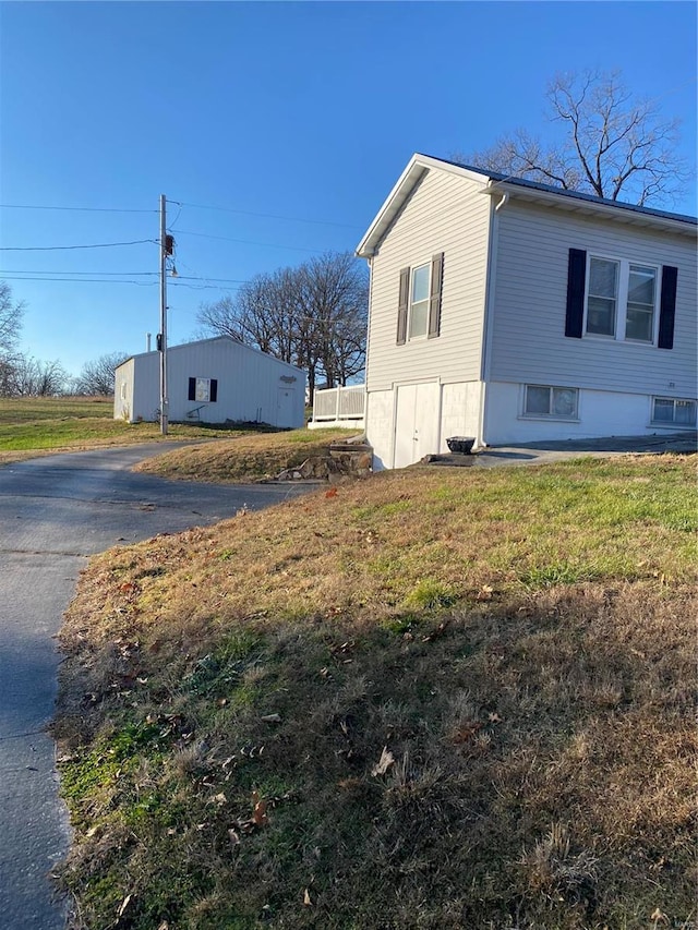 view of side of home featuring driveway and a yard