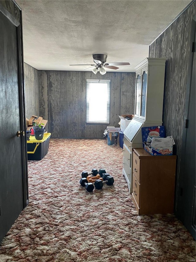 unfurnished room featuring carpet flooring, ceiling fan, and a textured ceiling