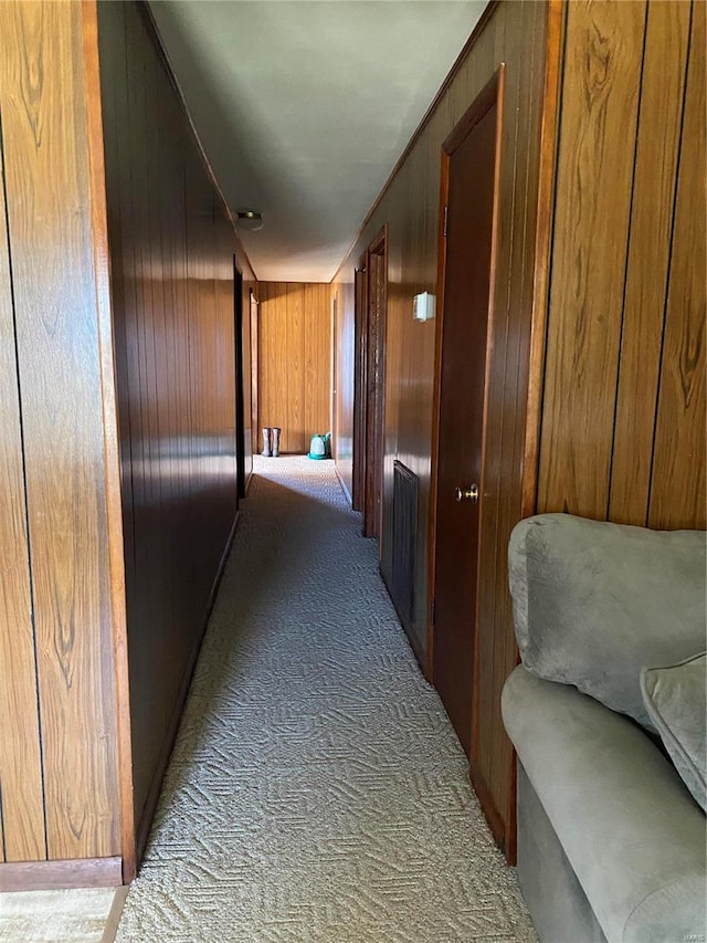 hall featuring carpet and wood walls