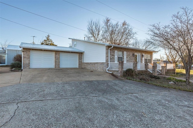 1728 Hitching Post Ln, Farmington, MO 63640 - view of front of property featuring concrete driveway, a porch, brick siding, and a garage