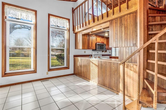 1728 Hitching Post Ln, Farmington, MO 63640 - kitchen featuring stainless steel microwave, brown cabinetry, baseboards, range, and a peninsula