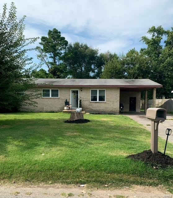 single story home with brick siding, a carport, and driveway