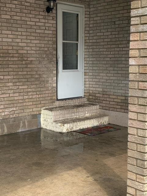 entrance to property featuring brick siding