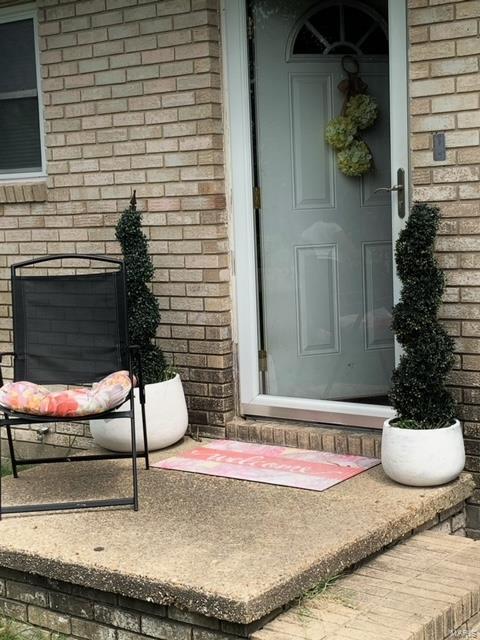 doorway to property with brick siding