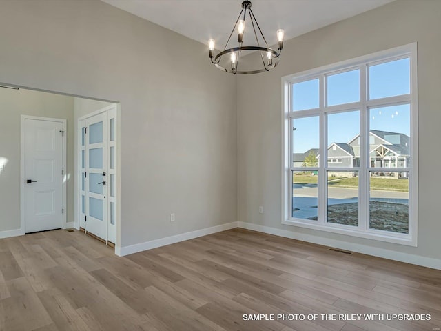 428 Hayden Dr, Waterloo, IL 62298 - unfurnished dining area with a chandelier, light wood-style floors, and baseboards