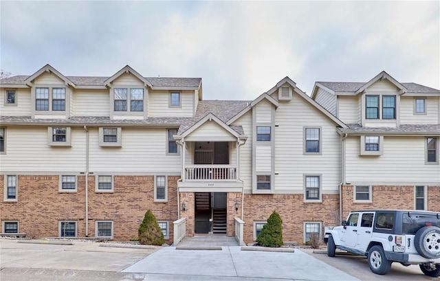 view of front of home featuring a balcony and brick siding