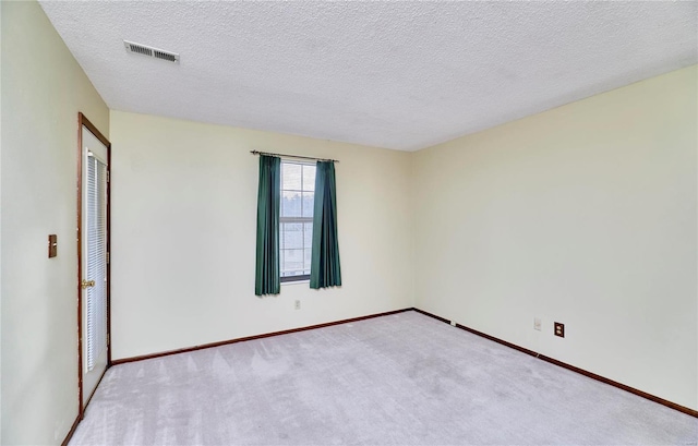 carpeted empty room featuring baseboards and a textured ceiling