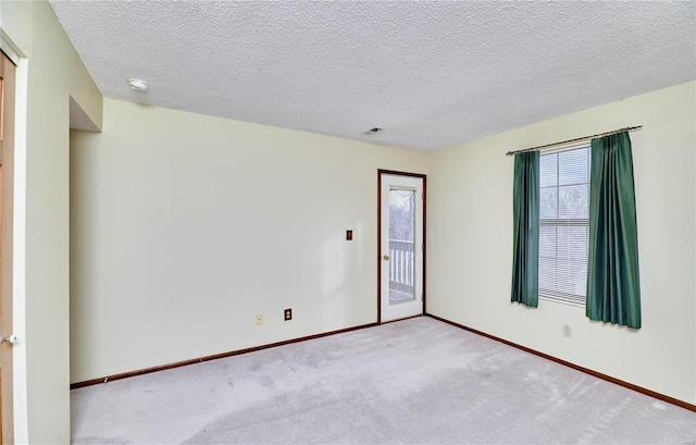 unfurnished room with carpet flooring, baseboards, a textured ceiling, and a smoke detector