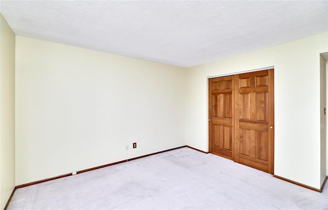 unfurnished bedroom featuring carpet flooring, baseboards, and a textured ceiling