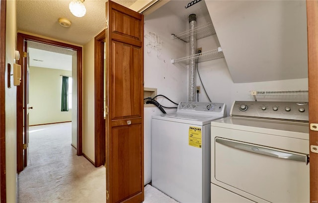 washroom with washing machine and dryer and light carpet