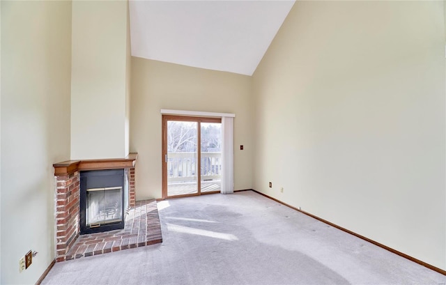 unfurnished living room with carpet floors, a brick fireplace, high vaulted ceiling, and baseboards