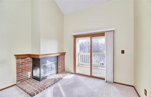 unfurnished living room featuring carpet flooring, baseboards, a brick fireplace, and lofted ceiling