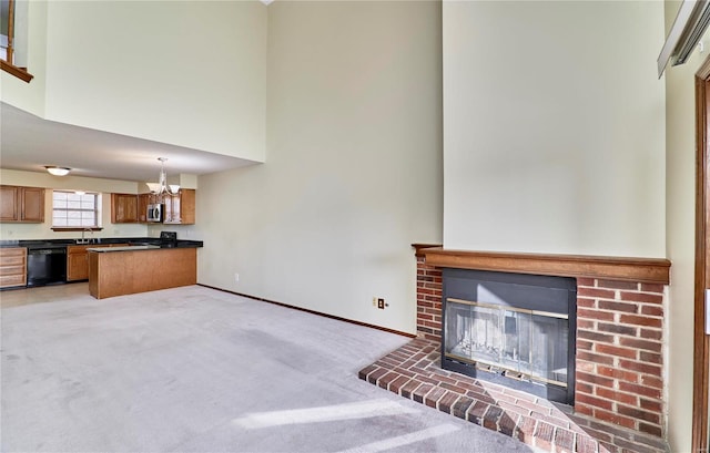unfurnished living room featuring a chandelier, a sink, a towering ceiling, a fireplace, and light carpet