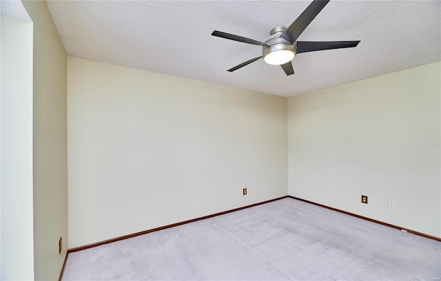empty room with ceiling fan, carpet flooring, a textured ceiling, and baseboards