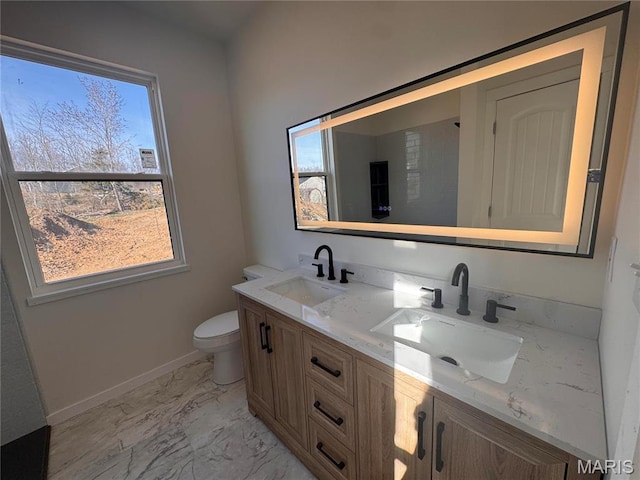 full bath featuring marble look tiles, double vanity, toilet, and baseboards