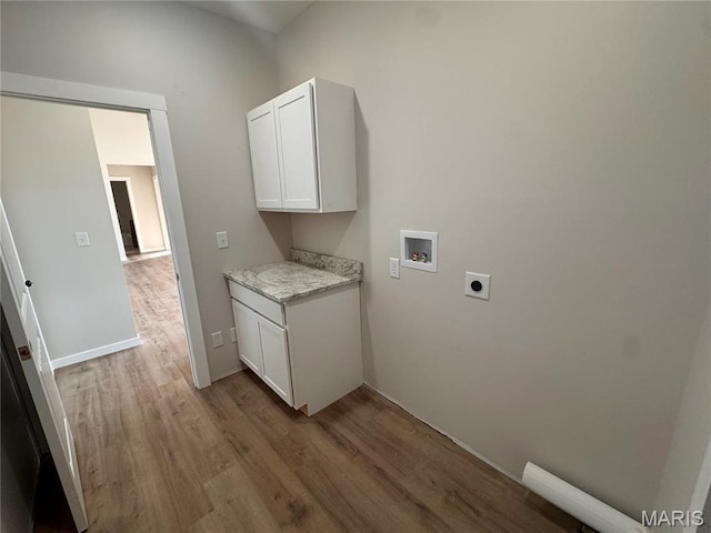 laundry room with hookup for an electric dryer, washer hookup, wood finished floors, cabinet space, and baseboards