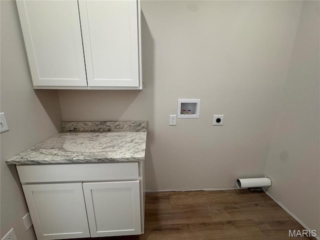 clothes washing area with hookup for a washing machine, hookup for an electric dryer, wood finished floors, and cabinet space
