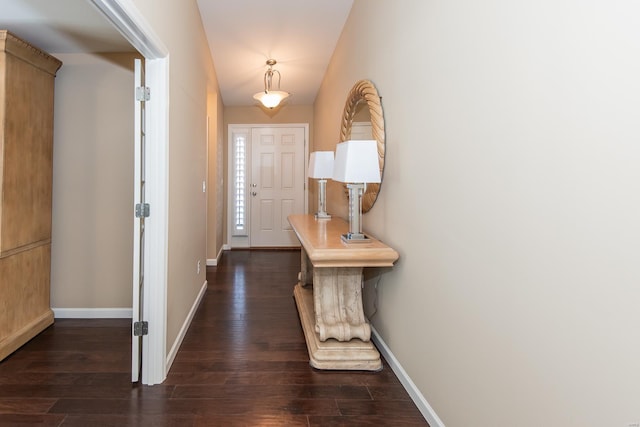 entrance foyer with dark wood-style flooring and baseboards