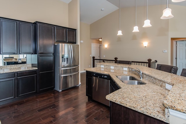 kitchen featuring stainless steel appliances, a sink, high vaulted ceiling, a kitchen bar, and dark wood finished floors