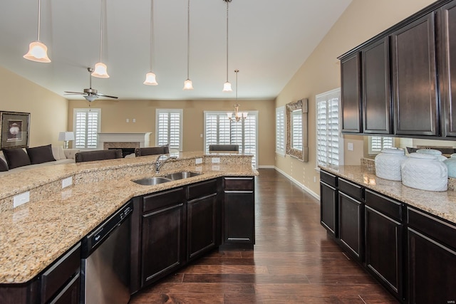 kitchen with stainless steel dishwasher, lofted ceiling, a fireplace, dark wood-type flooring, and a sink