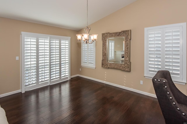 dining area featuring a chandelier, wood finished floors, lofted ceiling, and healthy amount of natural light