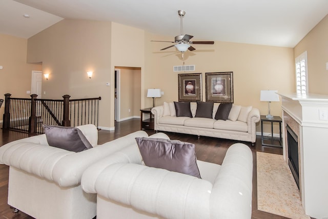 living area featuring ceiling fan, dark wood-style floors, baseboards, a fireplace, and high vaulted ceiling