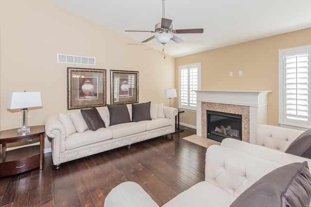 living room with vaulted ceiling, hardwood / wood-style floors, ceiling fan, a fireplace, and baseboards