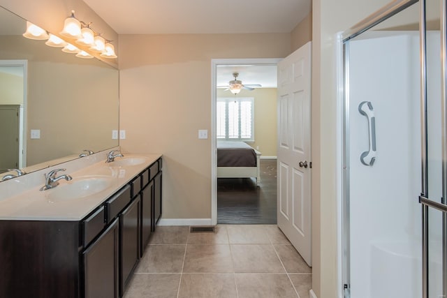 ensuite bathroom featuring tile patterned floors, baseboards, a stall shower, ceiling fan, and double vanity
