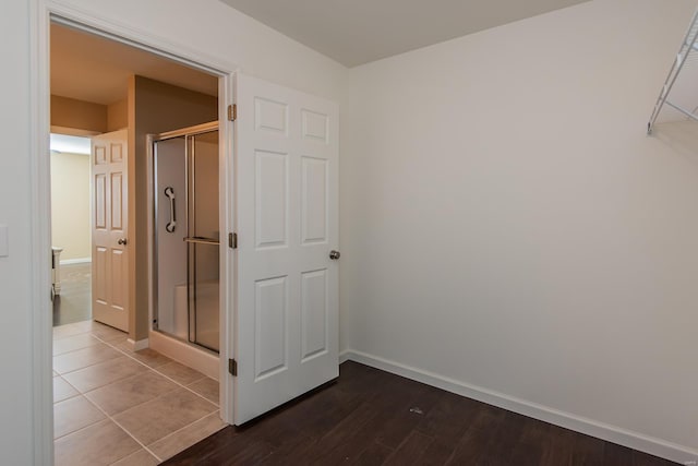 corridor with baseboards and dark wood-type flooring