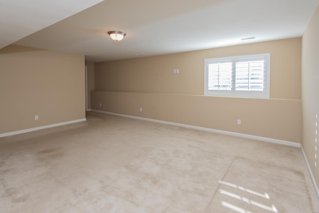 unfurnished room featuring baseboards and light carpet