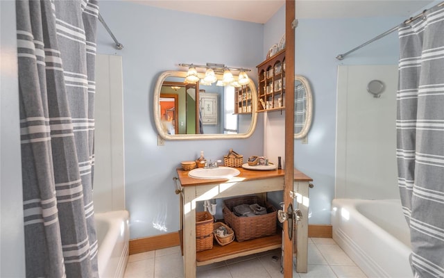 full bath featuring shower / bath combo with shower curtain, tile patterned floors, and baseboards