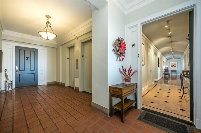 tiled entryway featuring crown molding, baseboards, and elevator