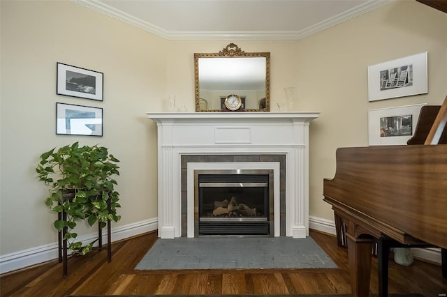 detailed view of baseboards, a tile fireplace, wood finished floors, and crown molding