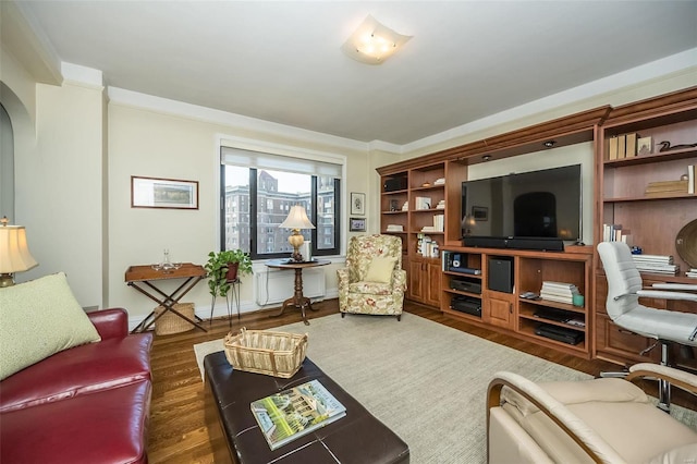 living room featuring wood finished floors, arched walkways, and crown molding