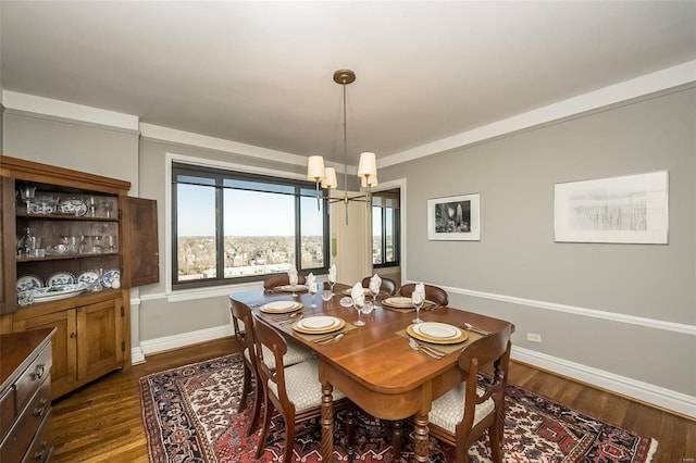 dining room with a chandelier, dark wood finished floors, and baseboards