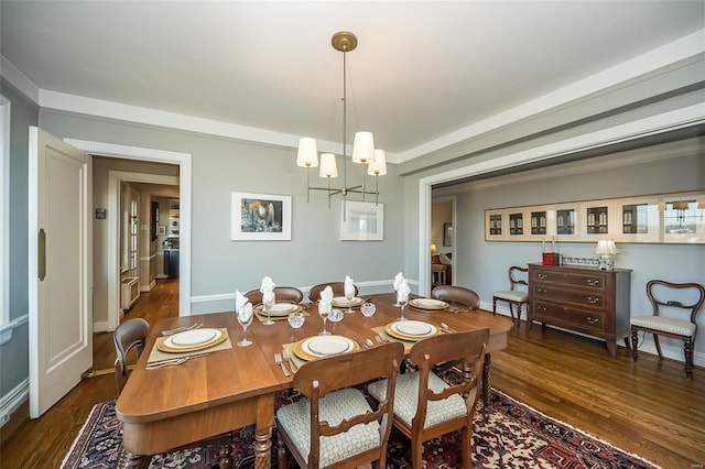dining space featuring a chandelier, dark wood-style floors, and baseboards